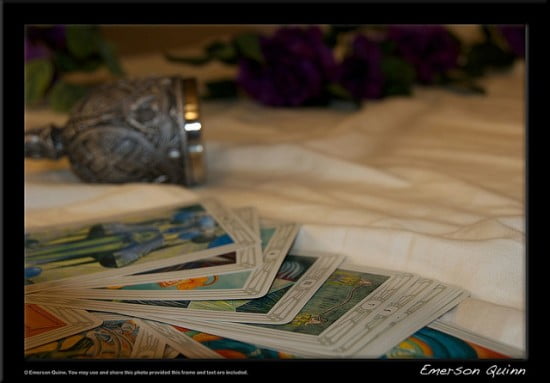Tarot cards and gothic pewter goblet rest on bed